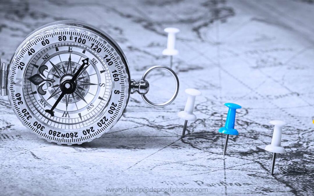 Landkarte mit verschiedenfarbigen Pins und einem Kompass