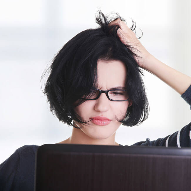 Junge Frau rauft sich die Haare vor dem computer